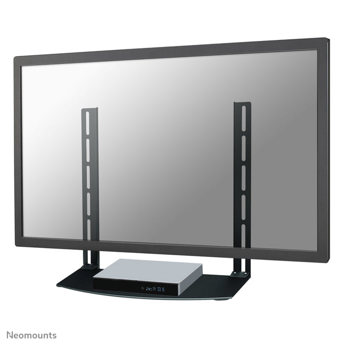Uchwyt AV Neomounts, model NS-SHELF100, jest idealny do umieszczania sprzętu AV pod uchwytami do ekranów płaskich.